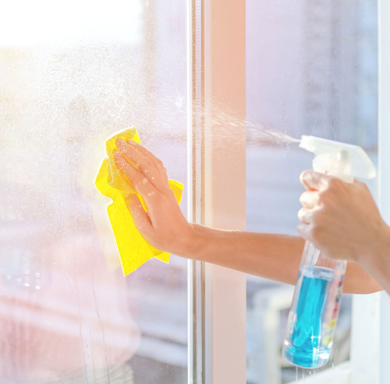 Hands with napkin cleaning window. Washing the glass on the windows with cleaning spray. Selective soft focus. Empty place for text, copy space. Window cleaning home.